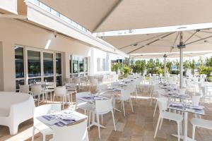 un restaurante con mesas blancas y sillas blancas en Westotel Tours Val de Loire en La Ville-aux-Dames