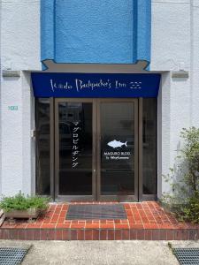 a store front with a blue awning on a building at MAGURO BLDG チェックインはWhyKumano in Nachikatsuura