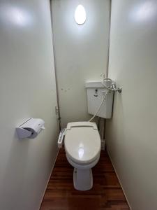 a small bathroom with a toilet in a stall at MAGURO BLDG チェックインはWhyKumano in Nachikatsuura
