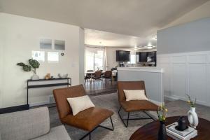 a living room with chairs and a table and a kitchen at Friends and Family! 5 Bed Mountain Getaway 20 Mi to Park City in Heber City