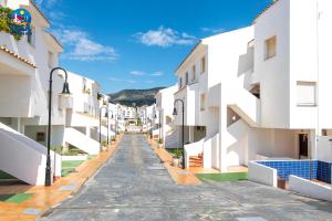 pusta ulica w mieście z białymi budynkami w obiekcie Apartamentos Poblado Marinero Casa Azahar w mieście Alcossebre