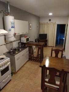 a kitchen with a table and a stove and a table sidx sidx at Departamento amoblado Rio Cuarto in Río Cuarto