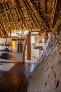 Loisaba Star Beds في Tura: غرفة مع أرضية خشبية وسقف خشبي