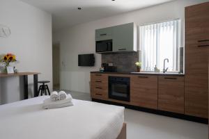 um quarto com uma cozinha com uma cama e um lavatório em Marina Studios em Cospicua