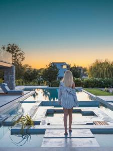 una donna in piedi di fronte a una piscina di Allure Wellness Retreat a Città di Lefkada