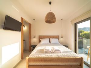 a bedroom with a bed with two towels on it at Allure Wellness Retreat in Lefkada Town