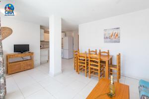 cocina y comedor con mesa y TV en Apartamentos Poblado Marinero Casa Azahar, en Alcossebre