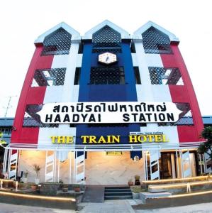 a train hotel with a clock on the front of it at The Train Hotel Hatyai in Hat Yai