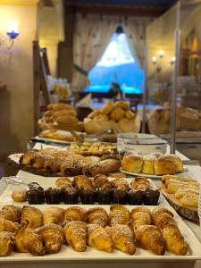 un montón de donuts y pasteles en exhibición en una panadería en Hotel Garni LIVING en San Candido