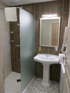 a bathroom with a sink and a shower with a mirror at Hotel MEDITERRANEO in Ybbs an der Donau