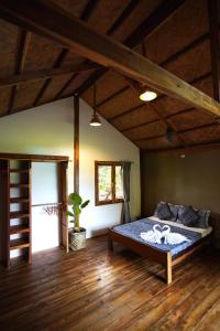 a bedroom with a bed in a room with wooden floors at Fisheye Villa in El Nido