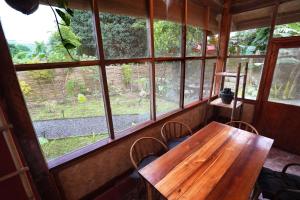 a wooden table and chairs in a room with windows at Fisheye Villa in El Nido