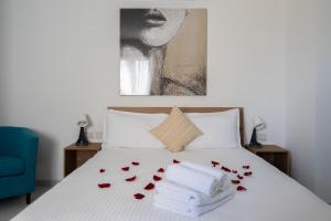 Una cama con rosas rojas y toallas. en Marina Studios, en Cospicua