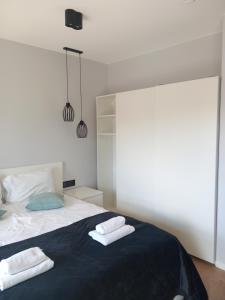 a bedroom with a bed with two towels on it at Old Town Nadmotławie - Sauna & Gym I 10min deptak in Gdańsk