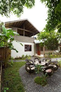 a group of chairs and tables in front of a house at Fisheye Villa in El Nido