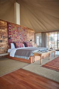 Loisaba Lodo Springs في Tura: غرفة نوم بسرير كبير وطاولة