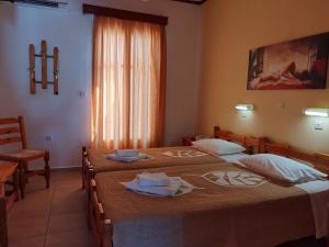 イオス島 チョーラにあるPoseidon Hotelのベッドルーム1室(ベッド2台、タオル付)