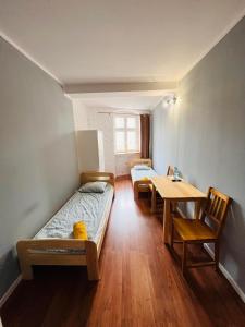 a room with two beds and a table and chairs at Hostel WOKU in Świebodzice