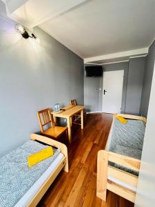 a small room with two beds and a table at Hostel WOKU in Świebodzice