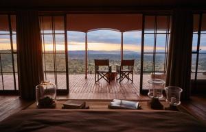 Loisaba Lodo Springs في Tura: غرفة نوم بسرير وإطلالة على الجبال