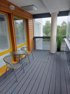 a porch with chairs and a table and windows at Apartment Kauppatie, neljälle hengelle in Laihia