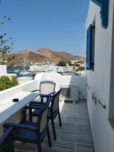 a balcony with chairs and a table on a building at Poseidon Hotel in Ios Chora