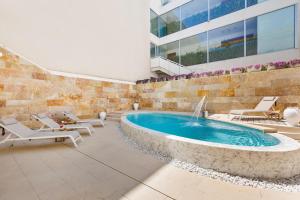 una piscina in un edificio con sedie a sdraio e una piscina di Palma Residence Salento a San Foca