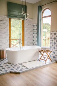 a bath tub in a bathroom with a window at Hotel Chateau Iveri in Varjanisi