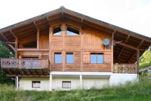 ein Holzhaus mit Balkon darüber in der Unterkunft Chalet Hibou in Les Gets