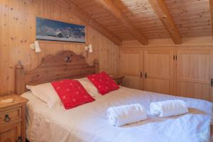 a bedroom with a bed with two red pillows on it at Chalet Hibou in Les Gets