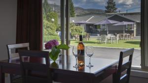 a table with a bottle of wine and two glasses at Valley Star Motel in Penticton