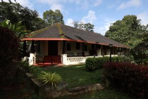 a house with a red roof and a yard at Avadale Coorg - Stag Groups Not Allowed in Ammatti