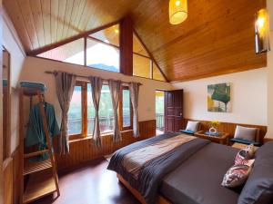 a bedroom with a bed and a large window at Molly's Cottage in Manāli
