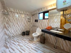 a bathroom with a toilet and a sink at Molly's Cottage in Manāli