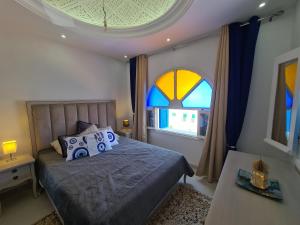 a bedroom with a bed and a large window at Villa Bleue plage Sonia in Zarzis