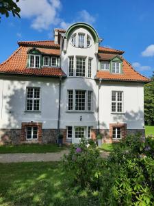 una gran casa blanca con techo rojo en Kamin-Stuuv, en Stubbendorf
