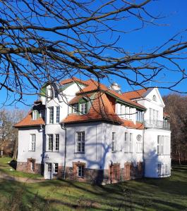 una gran casa blanca con techo naranja en Kamin-Stuuv, en Stubbendorf