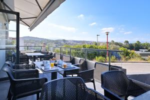 a patio with tables and chairs and a view of the mountains at Résidence Easy Lodge in Ajaccio