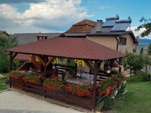 a gazebo with flowers in front of a house at Casa Alex in Topliţa