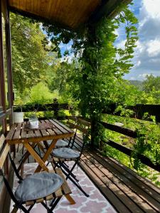 a wooden table and chairs on a porch with a fence at Gästehaus auf tollem Anwesen in Neubulach