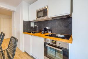 a kitchen with a sink and a microwave at Appartement Wilsonia - Welkeys in Antibes