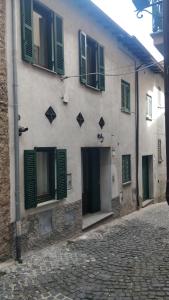 a building with green shutters on a street at Agriturismo Lo Scoiattolo in Ronciglione