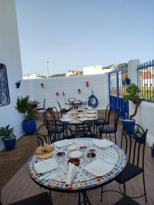 eine Gruppe von Tischen und Stühlen auf einer Terrasse in der Unterkunft Maison d'Hôtes Casa Azla in Azla