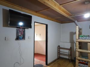 um quarto com uma televisão de ecrã plano na parede em Kingfern em Nuwara Eliya