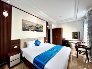 een slaapkamer met een bed en een bureau in een kamer bij Khách sạn Ngọc Hà in Lao Cai