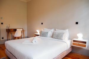 um quarto com uma grande cama branca e uma secretária em Trait House em Porto