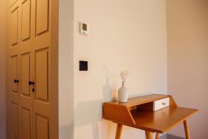um quarto com uma mesa de madeira e um vaso sobre ele em Trait House no Porto