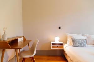 um quarto com uma secretária, uma cama, uma secretária e uma cadeira. em Trait House em Porto