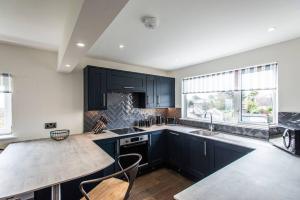 a kitchen with black cabinets and a counter top at 10 Boskenza Court in Carbis Bay