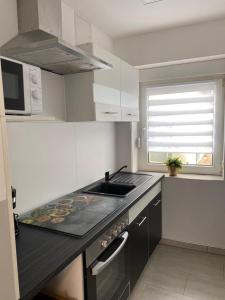 a small kitchen with a sink and a microwave at Ferienwohnung H&M Immobilien Hettstedt 2 in Hettstedt